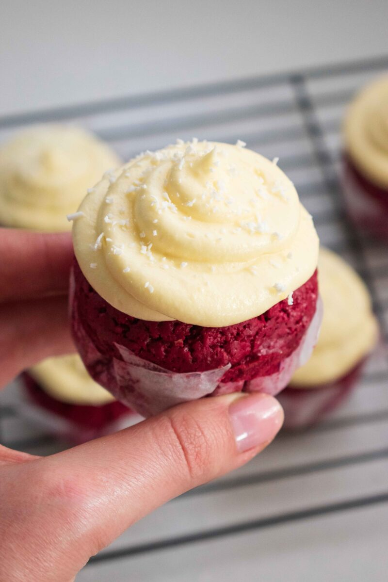 A red velvel cupcake held by Lila Lerie's hand