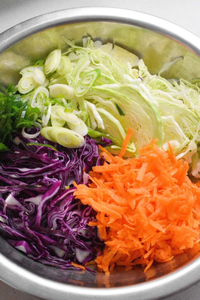 Carrot Green and purple gabbage in a stainlessteel bowl