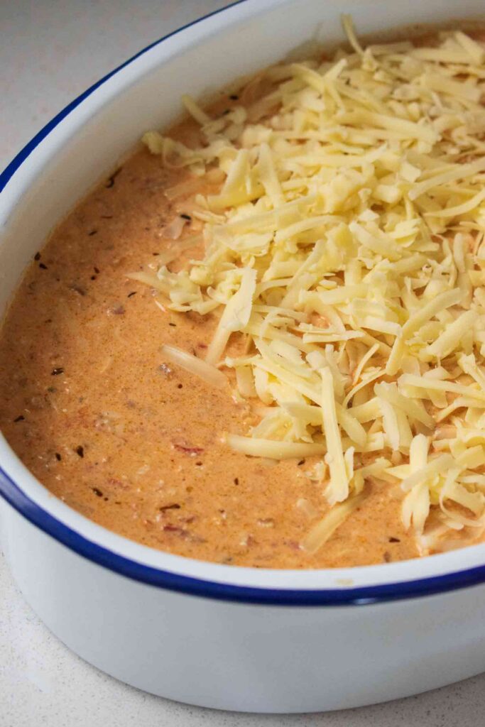 #pap #paptert a oven dish with the paptert ingredients with grated cheese on top not baked yet.