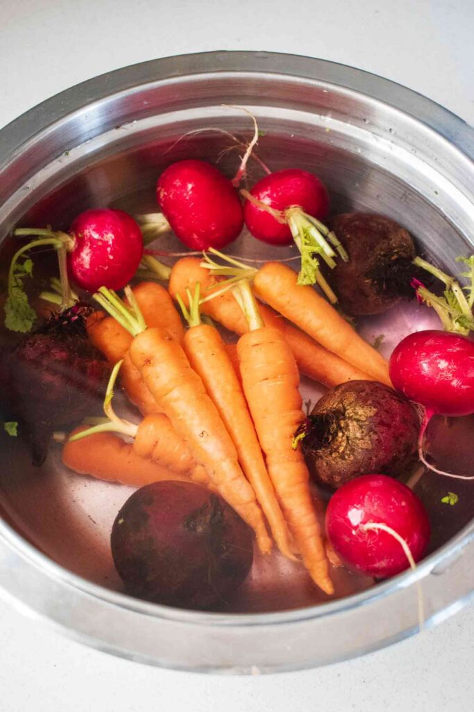 A stainless steel bowl filled with Root vegetables